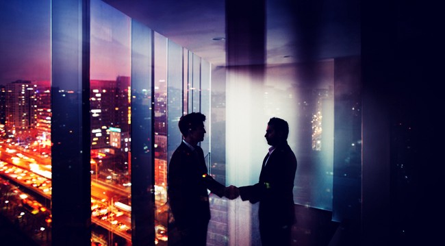 Two men in a building shaking hands